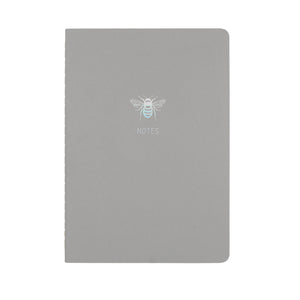 A5 SIZE NOTEBOOK BEE NOTES HOLOGRAPHIC FOILED COVER DETAIL, CARDBOARD COVER COLOR GREY, INTERIOR DOTTED, ROUNDED CORNERS, VISIBLE SINGER STITCHING ON THE SPINE, INTERIOR PAPER IVORY-COLORED 90 GMS, ACID FREE PAPER MADE IN COLOMBIA BY MAKE2D