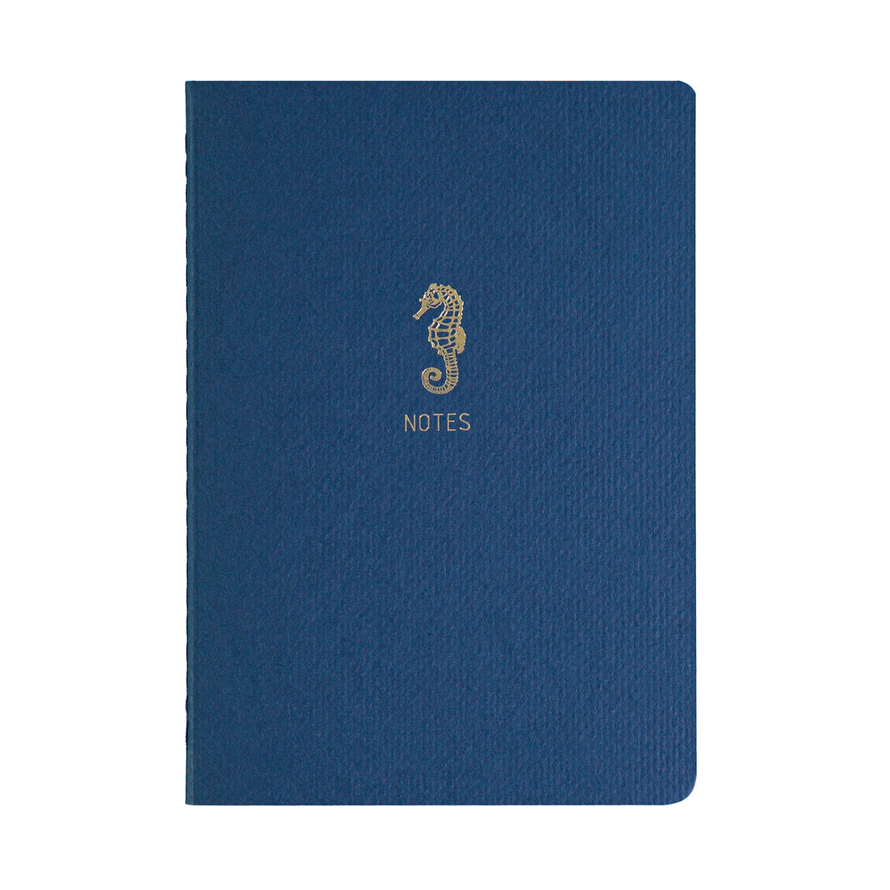 A5 SIZE NOTEBOOK SEAHORSE NOTES FOILED COVER DETAIL, CARDBOARD COVER COLOR BLUE, INTERIOR DOTTED, ROUNDED CORNERS, VISIBLE SINGER STITCHING ON THE SPINE, INTERIOR PAPER IVORY-COLORED 90 GMS, ACID FREE PAPER MADE IN COLOMBIA BY MAKE2D