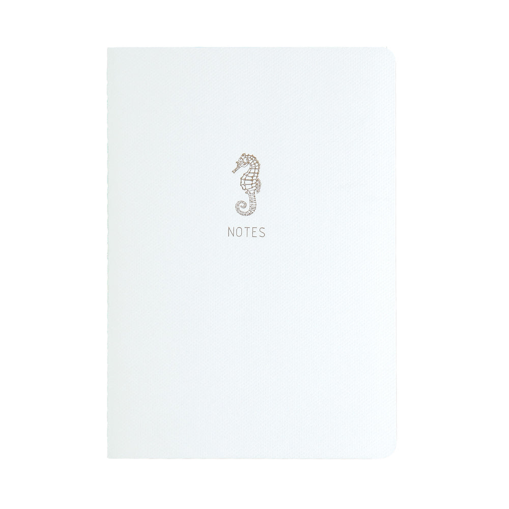A5 SIZE NOTEBOOK SEAHORSE NOTES FOILED COVER DETAIL, CARDBOARD COVER COLOR WHITE, INTERIOR DOTTED, ROUNDED CORNERS, VISIBLE SINGER STITCHING ON THE SPINE, INTERIOR PAPER IVORY-COLORED 90 GMS, ACID FREE PAPER MADE IN COLOMBIA BY MAKE2D