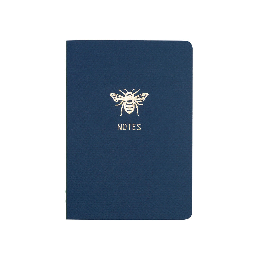 
                
                    Load image into Gallery viewer, A6 POCKET SIZE NOTEBOOK BEE NOTES GOLD FOILED COVER DETAIL, CARDBOARD COVER COLOR BLUE, INTERIOR DOTTED OR RULED, ROUNDED CORNERS, VISIBLE SINGER STITCHING ON THE SPINE, INTERIOR PAPER IVORY-COLORED 90 GMS, ACID FREE PAPER MADE IN COLOMBIA BY MAKE2D
                
            