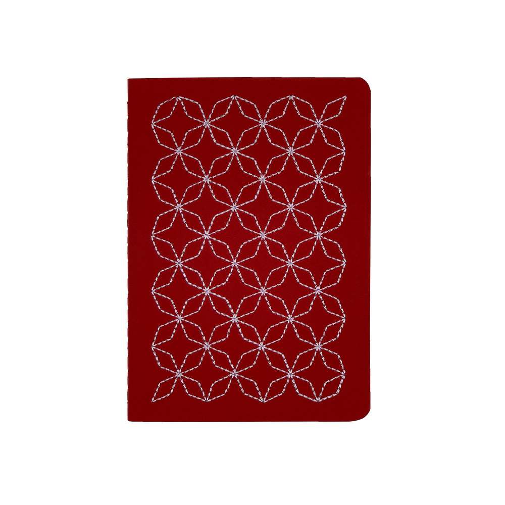 A6 POCKET SIZE NOTEBOOK EMBOROIDERED TOKYO COVER DETAIL, CARDBOARD COVER COLOR RED, LILAC EMBROIDERY, INTERIOR DOTTED OR RULED, ROUNDED CORNERS, VISIBLE SINGER STITCHING ON THE SPINE, INTERIOR PAPER IVORY-COLORED 90 GMS, ACID FREE PAPER BACK GOLD FOIL COVER DETAIL MADE IN COLOMBIA BY MAKE2D