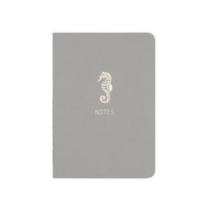 A6 POCKET SIZE NOTEBOOK SEAHORSE NOTES GOLD FOILED COVER DETAIL, CARDBOARD COVER COLOR GREY, INTERIOR DOTTED OR RULED, ROUNDED CORNERS, VISIBLE SINGER STITCHING ON THE SPINE, INTERIOR PAPER IVORY-COLORED 90 GMS, ACID FREE PAPER MADE IN COLOMBIA BY MAKE2D