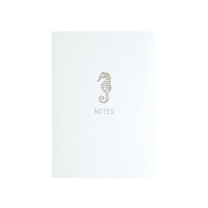 A6 POCKET SIZE NOTEBOOK SEAHORSE NOTES GOLD FOILED COVER DETAIL, CARDBOARD COVER COLOR WHITE, INTERIOR DOTTED OR RULED, ROUNDED CORNERS, VISIBLE SINGER STITCHING ON THE SPINE, INTERIOR PAPER IVORY-COLORED 90 GMS, ACID FREE PAPER MADE IN COLOMBIA BY MAKE2D